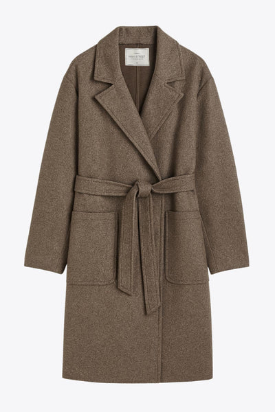 Abrigo largo de manga larga, con solapa, bolsillos delanteros de parche, trabillas y cinturón amarrable del mismo tejido.