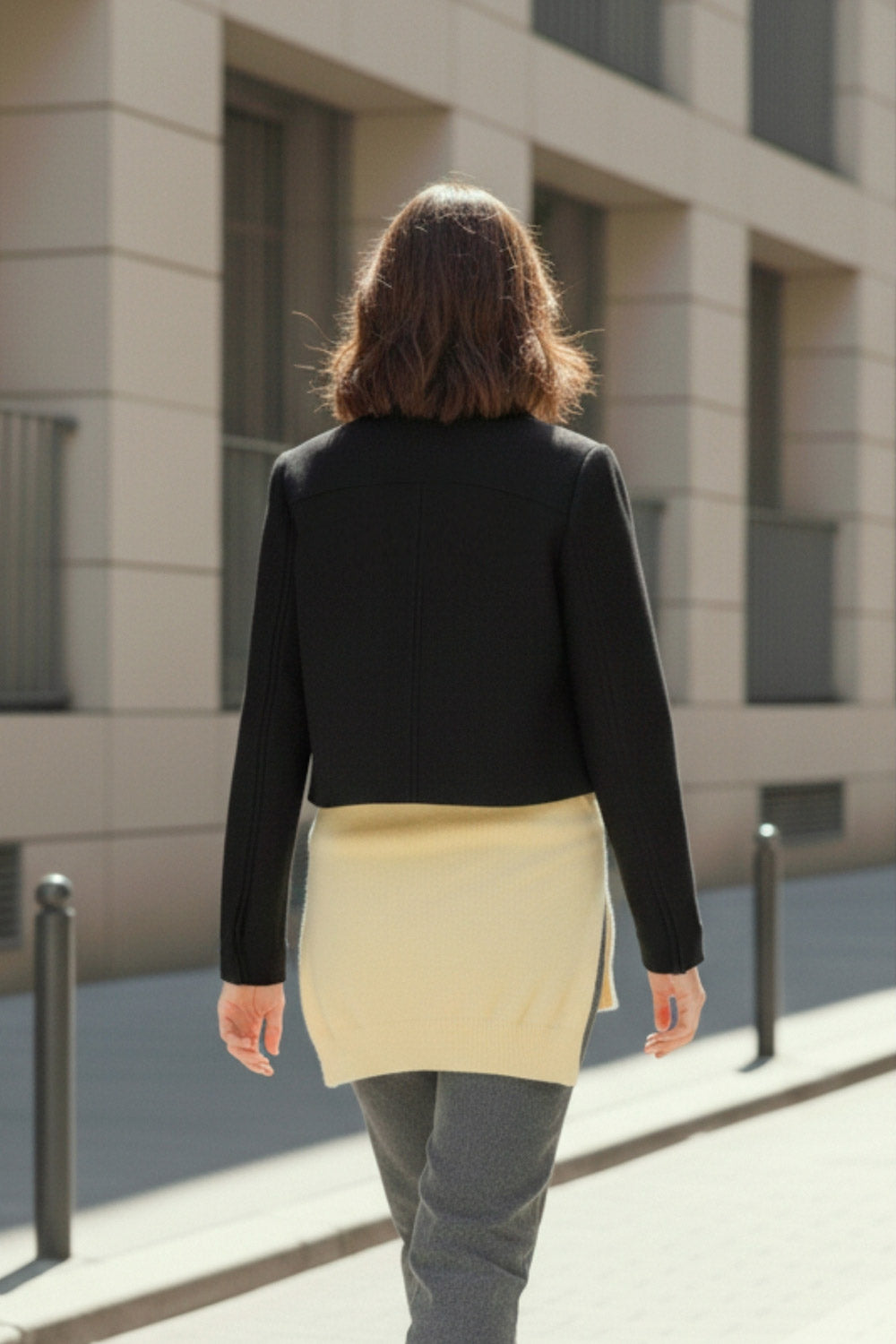 Abrigo corto de fit recto, manga larga, cuello solapa, bolsillos delanteros de parche con cartera y cierre frontal con hilera de botones en contraste.