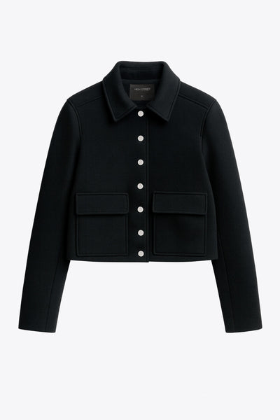 Abrigo corto de fit recto, manga larga, cuello solapa, bolsillos delanteros de parche con cartera y cierre frontal con hilera de botones en contraste.