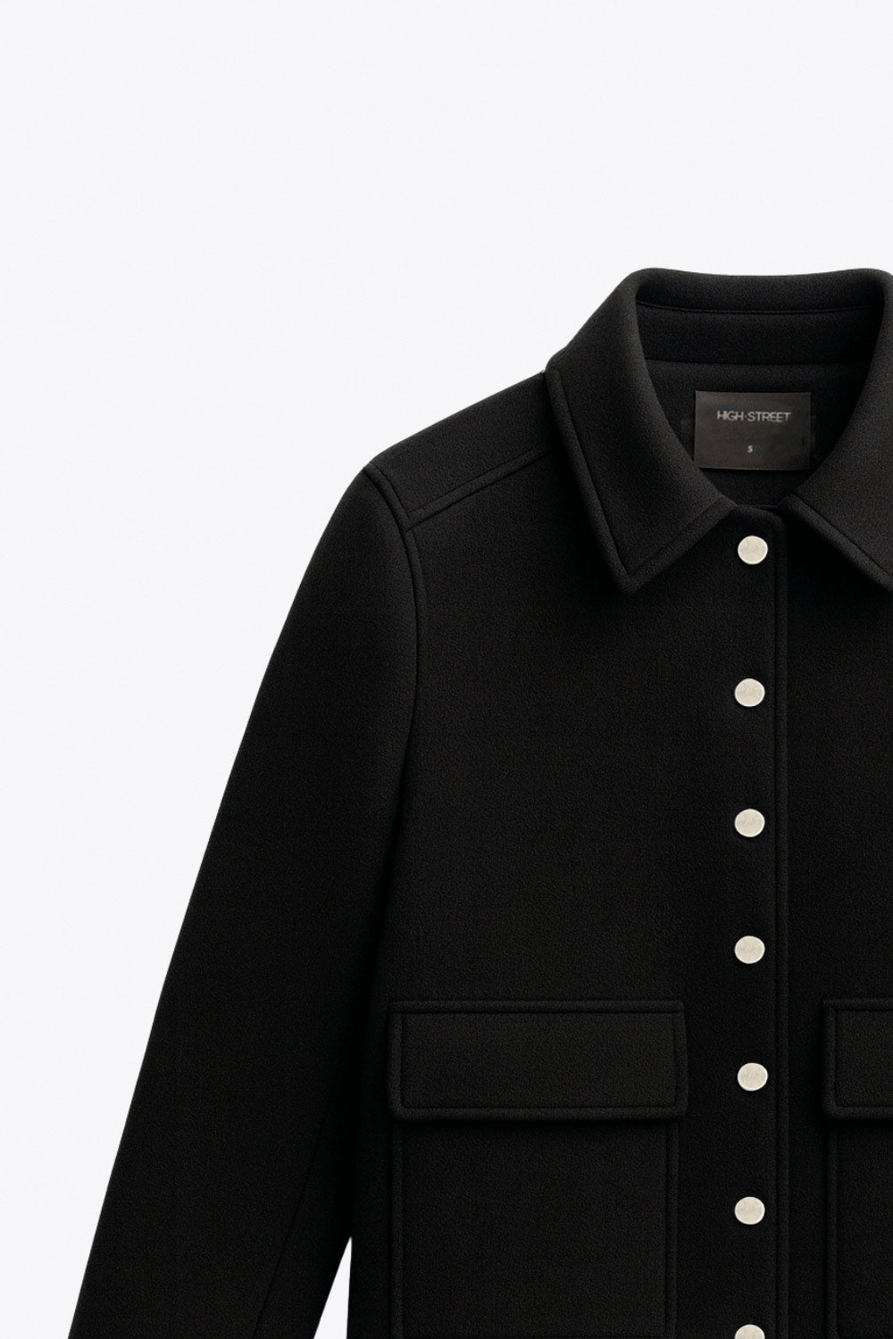 Abrigo corto de fit recto, manga larga, cuello solapa, bolsillos delanteros de parche con cartera y cierre frontal con hilera de botones en contraste.