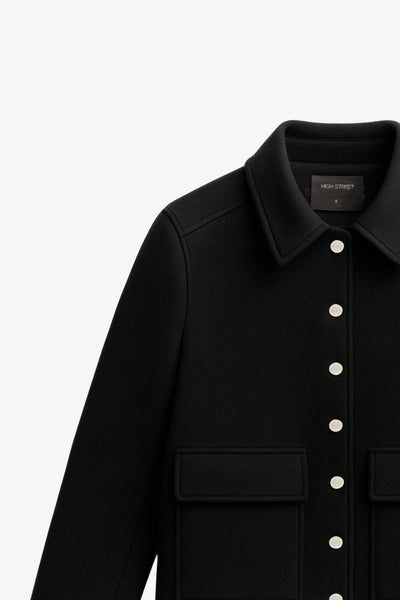 Abrigo corto de fit recto, manga larga, cuello solapa, bolsillos delanteros de parche con cartera y cierre frontal con hilera de botones en contraste.