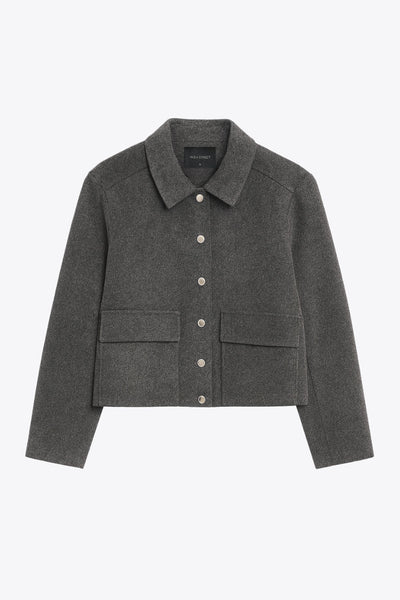 Abrigo corto de fit recto, manga larga, con cuello solapa, bolsillos delanteros de parche con cartera y cierre frontal con botones en contraste.