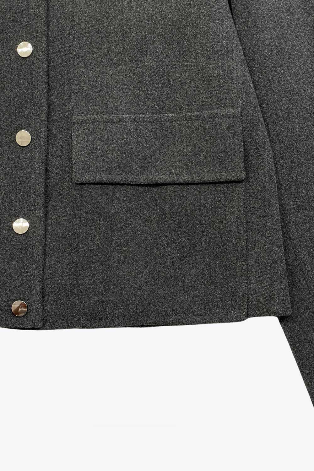 Abrigo corto de fit recto, manga larga, con cuello solapa, bolsillos delanteros de parche con cartera y cierre frontal con botones en contraste.