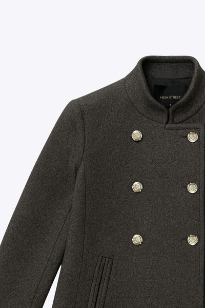 Abrigo cruzado de cuello alto, bolsillos delanteros y manga larga. Cierre frontal con doble cruce de botones en contraste.