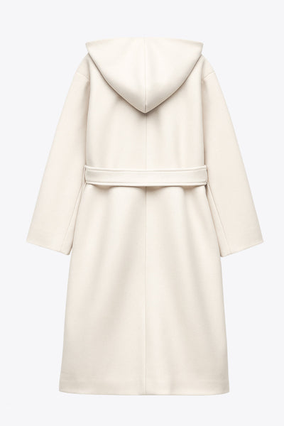 Abrigo largo de fit recto con capucha, manga larga y bolsillos delanteros. Detalle de trabillas y cinturón amarrable del mismo tejido.