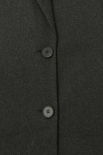 Abrigo largo de fit recto, con solapa y hombreras, manga larga, bolsillos delanteros con vivos y cierre frontal con botones en contraste.