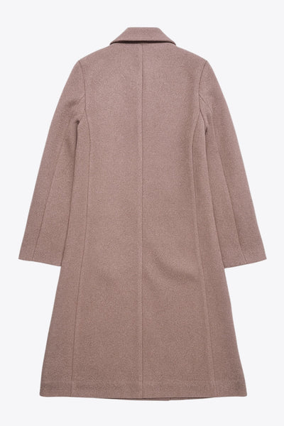 Abrigo largo de fit recto, manga larga, con solapa, bolsillos con vivos delanteros. Cierre frontal con cruce de botones en contraste.