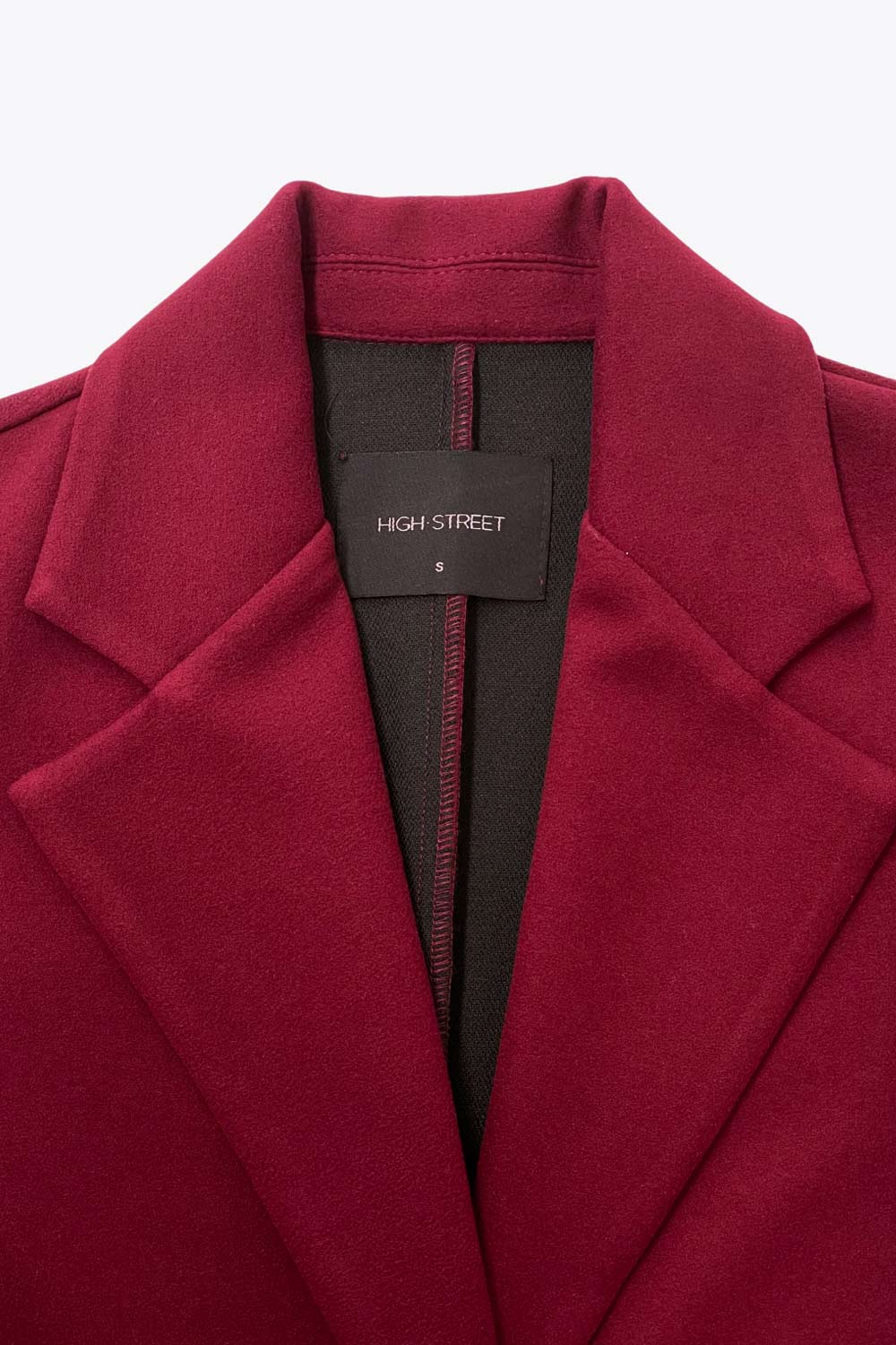 Abrigo largo de fit recto, manga larga, con solapa, bolsillos con vivos delanteros. Cierre frontal con cruce de botones en contraste.