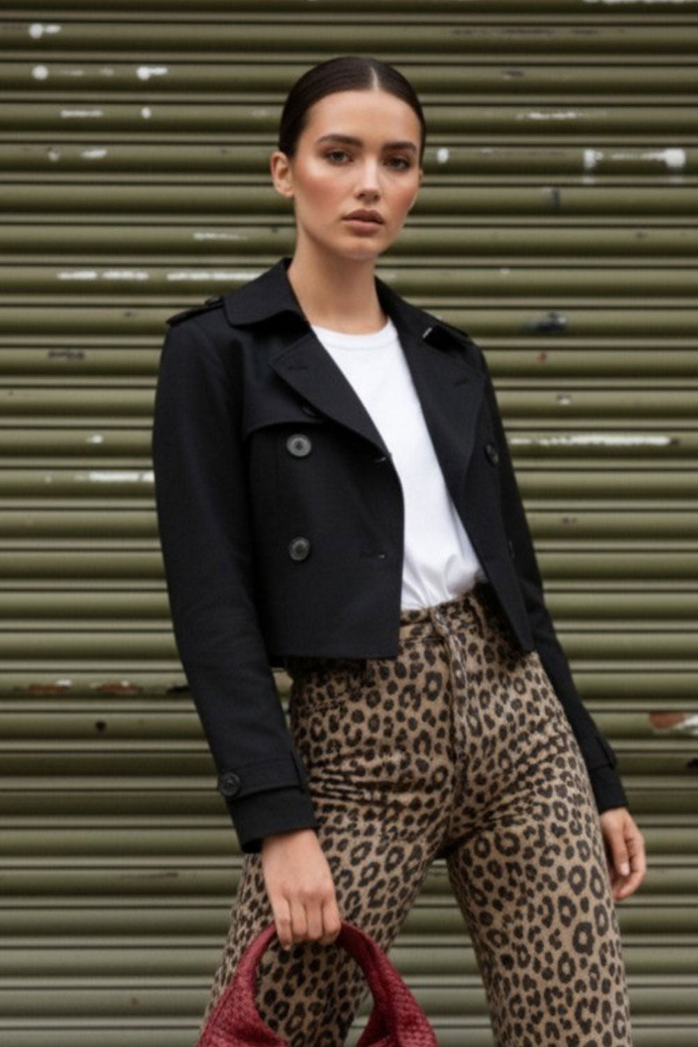 Abrigo trench corto de fit recto, cuello solapa, manga larga, trabillas con botón en puños y hombros. Bolsillos delanteros con vivos y cierre frontal con doble cruce de botones.