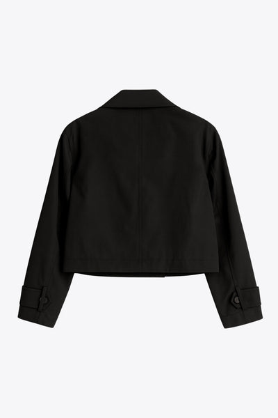 Abrigo trench corto de fit recto, cuello solapa, manga larga, trabillas con botón en puños y hombros. Bolsillos delanteros con vivos y cierre frontal con doble cruce de botones.