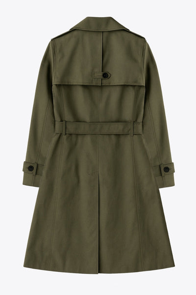 Abrigo trench corto de fit recto, con cuello solapa, bolsillos delanteros con vivos, detalle de bata trasera y manga larga. Trabillas, cinturón amarrable del mismo tejido y cierre frontal con doble cruce de botones en contraste. Detalle de trabilla y botón en hombros, bata trasera, cuello y puños.