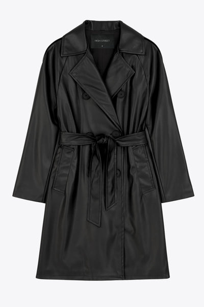 Abrigo trench de efecto piel, fit recto, con solapa, bolsillos delanteros con vivos, abertura posterior en bajo, bata trasera y manga larga. Cinturón amarrable del mismo tejido y cierre frontal con doble cruce de botones. Detalle de trabilla y botón en hombros y puños.