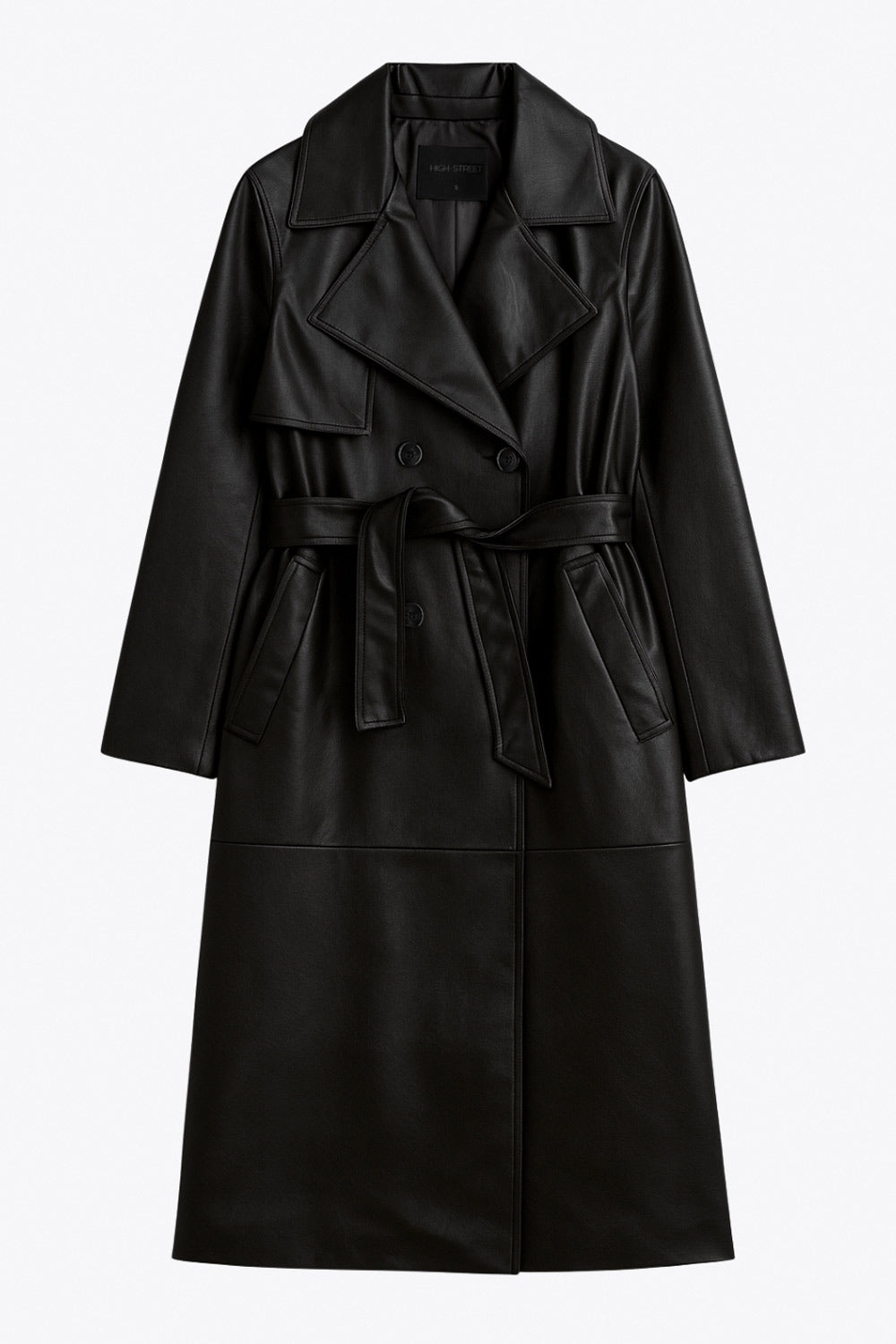 Abrigo trench largo de efecto piel, fit recto, manga larga, con solapa y bata en espalda, cortes decorativos frontales, trabillas y cinturón del mismo tejido con hebilla en contraste. Cierre frontal con doble cruce de botones en contraste.