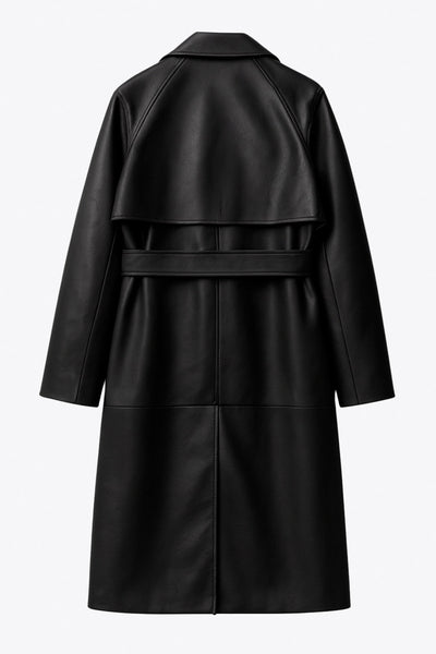 Abrigo trench largo de efecto piel, fit recto, manga larga, con solapa y bata en espalda, cortes decorativos frontales, trabillas y cinturón del mismo tejido con hebilla en contraste. Cierre frontal con doble cruce de botones en contraste.