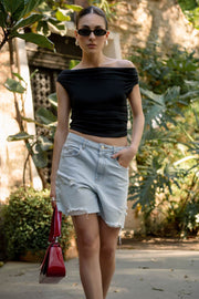 Bermuda corta de denim, fit recto, cintura media con pretina y trabillas, bolsillos delanteros y traseros de parche. Cierre frontal con botón y cremallera oculta. Detalle de rotos en bajo.