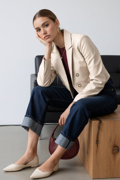 Blazer corto abierto de efecto piel, fit recto, con hombreras y solapa, manga larga y botones decorativos frontales en contraste.