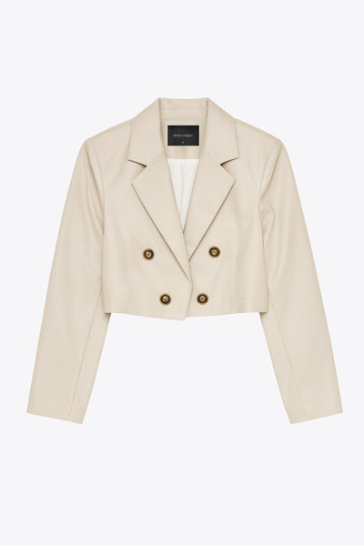 Blazer corto abierto de efecto piel, fit recto, con hombreras y solapa, manga larga y botones decorativos frontales en contraste.