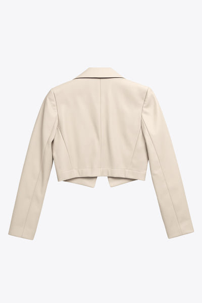 Blazer corto abierto de efecto piel, fit recto, con hombreras y solapa, manga larga y botones decorativos frontales en contraste.