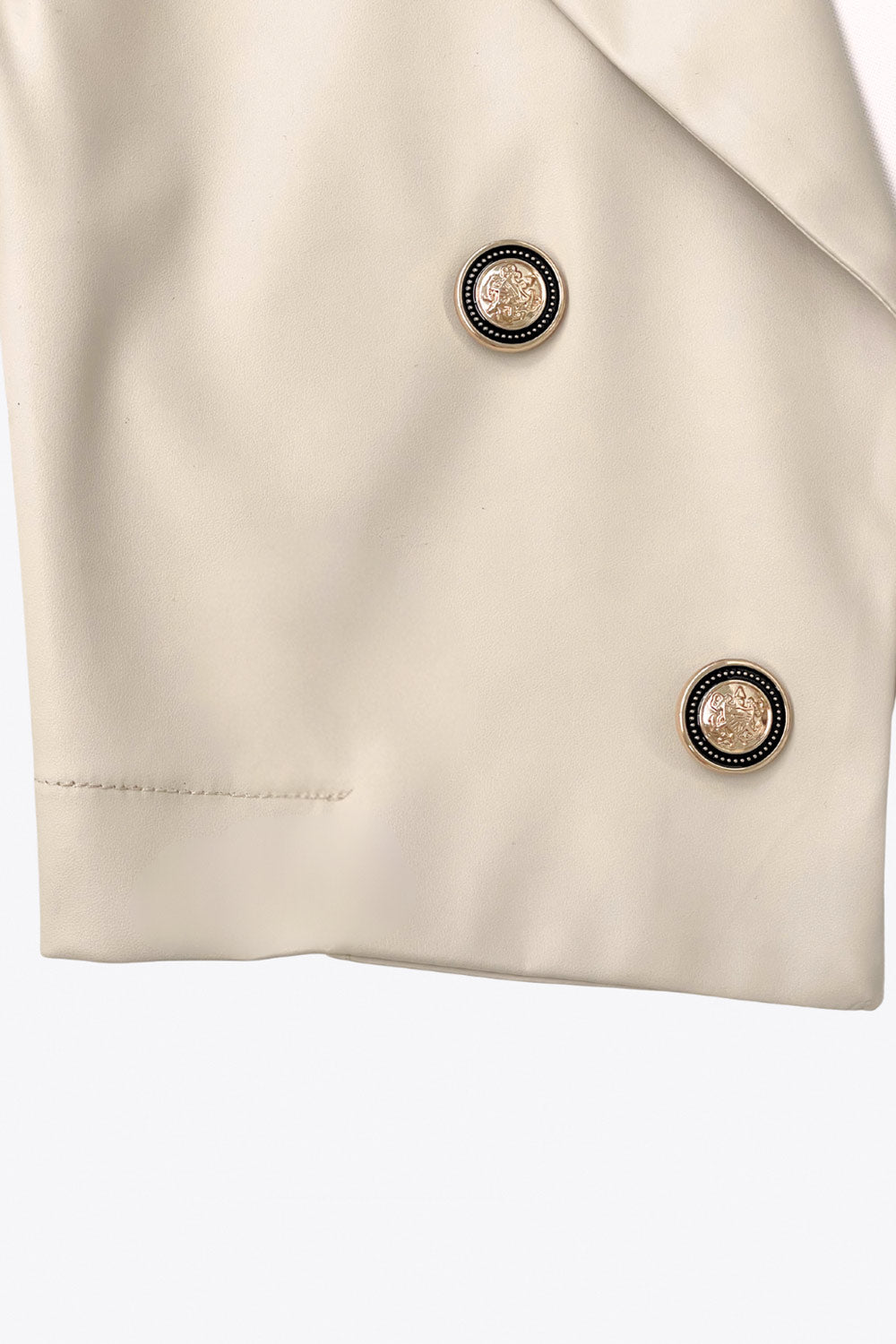 Blazer corto abierto de efecto piel, fit recto, con hombreras y solapa, manga larga y botones decorativos frontales en contraste.