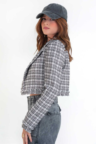 Blazer corto de bouclé, fit ajustado, con solapa, hombreras, manga larga y cierre frontal con botón en contraste. Detalle deshilado en bordes.