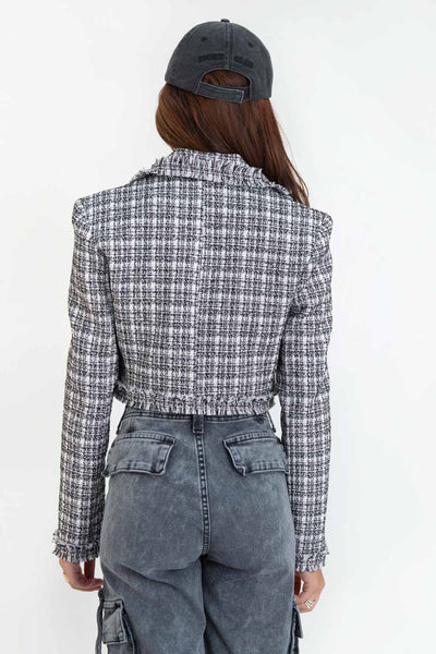 Blazer corto de bouclé, fit ajustado, con solapa, hombreras, manga larga y cierre frontal con botón en contraste. Detalle deshilado en bordes.
