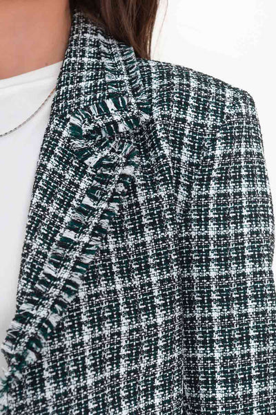 Blazer corto de bouclé, fit ajustado, con solapa, hombreras, manga larga y cierre frontal con botón en contraste. Detalle deshilado en bordes.