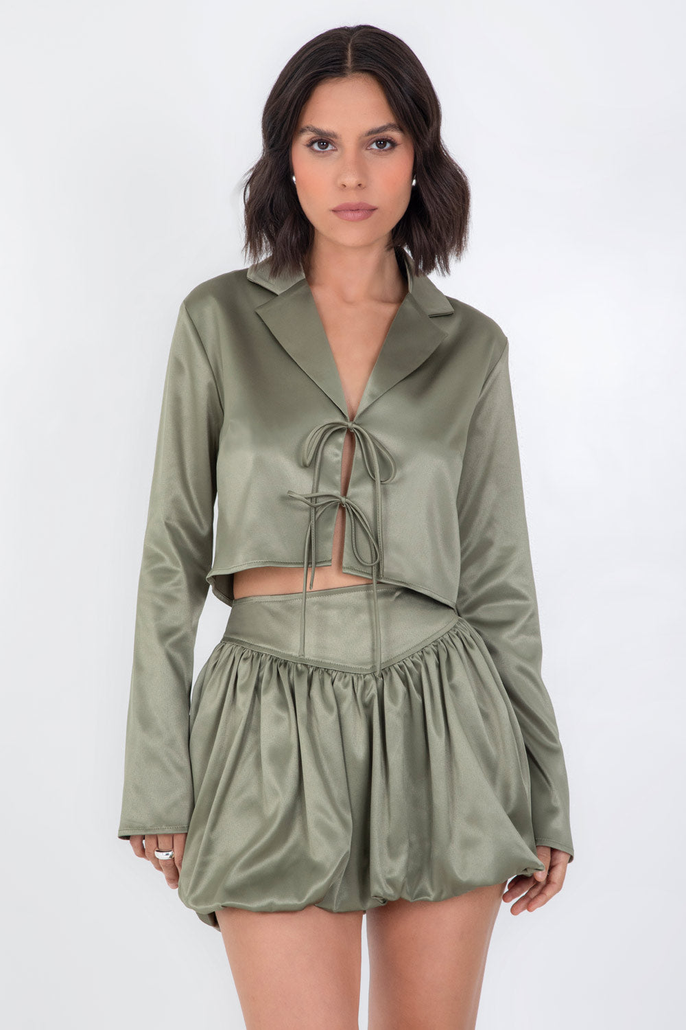 Blazer corto satinado de fit recto, manga larga, con solapa y cierre frontal con doble lazo amarrable.