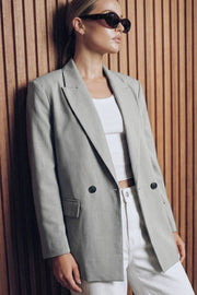 Blazer cruzado de fit oversized, con solapa y hombreras, manga larga, vivo frontal, bolsillos delanteros con cartera. Cierre frontal con cruce de botones.