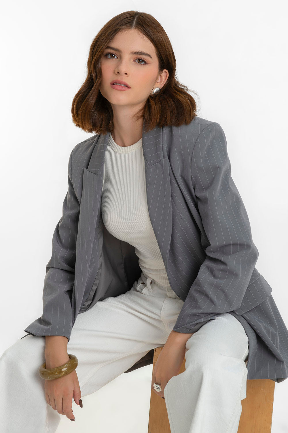 Blazer cruzado de estampado rayas, fit oversized, manga larga, bolsillos delanteros con cartera, con solapa y hombreras. Cierre frontal con cruce de botones en contraste.