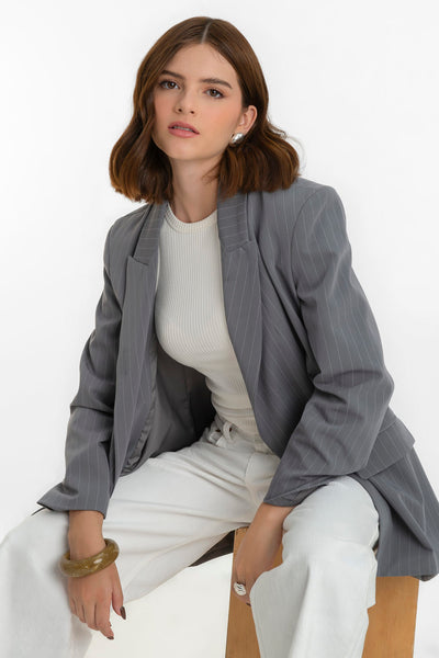 Blazer cruzado de estampado rayas, fit oversized, manga larga, bolsillos delanteros con cartera, con solapa y hombreras. Cierre frontal con cruce de botones en contraste.