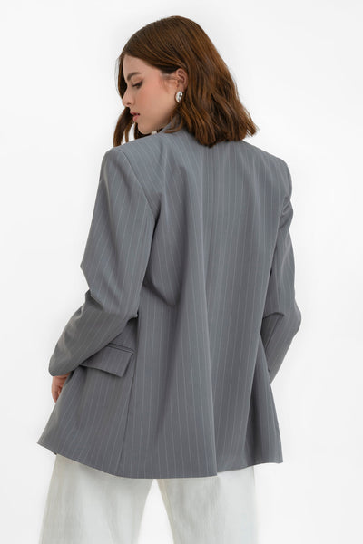 Blazer cruzado de estampado rayas, fit oversized, manga larga, bolsillos delanteros con cartera, con solapa y hombreras. Cierre frontal con cruce de botones en contraste.