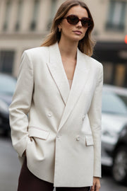 Blazer cruzado de fit oversized, con solapa y hombreras, manga larga, bolsillos delanteros con cartera y cierre frontal con cruce de botones.