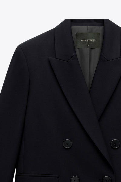 Blazer cruzado de fit oversized, con solapa y hombreras, manga larga y bolsillos delanteros con cartera. Cierre frontal con cruce de botones en contraste.