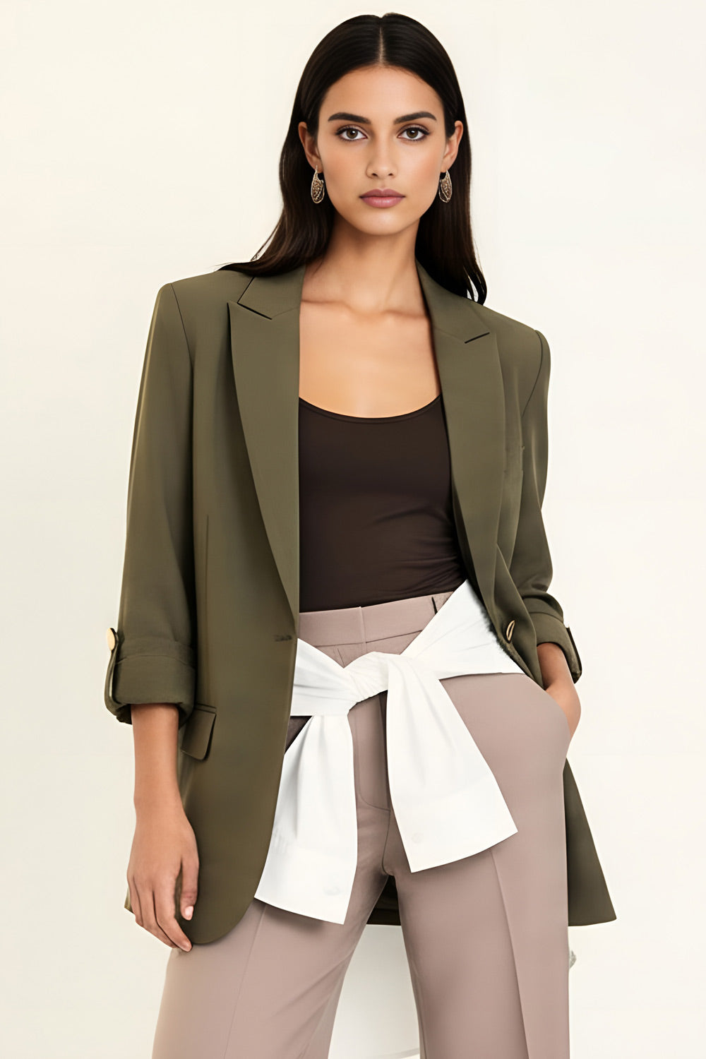 Blazer abierto de fit ligeramente oversized, manga 3/4 rolled up con trabilla decorativa y botón en contraste. Detalle de bolsillos delanteros con cartera.