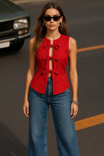 Blusa de fit ajustado, cuello redondo, sin mangas y cierre frontal con lazos amarrables. Detalle de bajo curveado frontal.