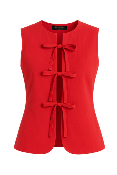 Blusa de fit ajustado, cuello redondo, sin mangas y cierre frontal con lazos amarrables. Detalle de bajo curveado frontal.