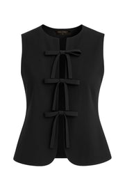 Blusa de fit ajustado, cuello redondo, sin mangas y cierre frontal con lazos amarrables. Detalle de bajo curveado frontal.