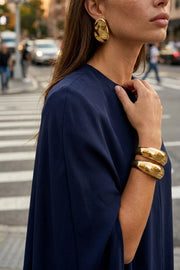 Blusa tipo túnica asimétrica, de cuello redondo, con hombreras, manga corta seguida, fit fluido y bajo asimétrico.