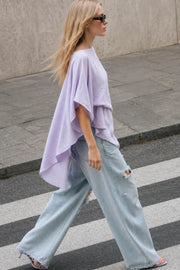 Blusa asimétrica de fit fluido, manga seguida con olanes, plisados y capas de olanes decorativos. Detalle de bajo asimétrico y textura en tejido.