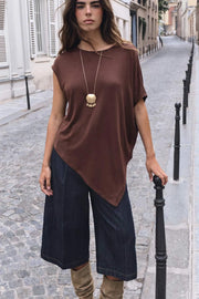 Blusa de fit fluido, cuello barco, manga corta seguida y bajo asimétrico diagonal.