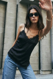 Blusa fluida larga de tirantes delgados ajustables, escote v con escote decorativo en contraste, cut out diagonal y bajo asimétrico frontal.