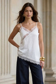 Blusa fluida larga de tirantes delgados ajustables, escote v con escote decorativo en contraste, cut out diagonal y bajo asimétrico frontal.