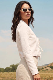Blusa corta de fit fluido, manga larga, escote v con solapa y cierre frontal con lazos amarrables.