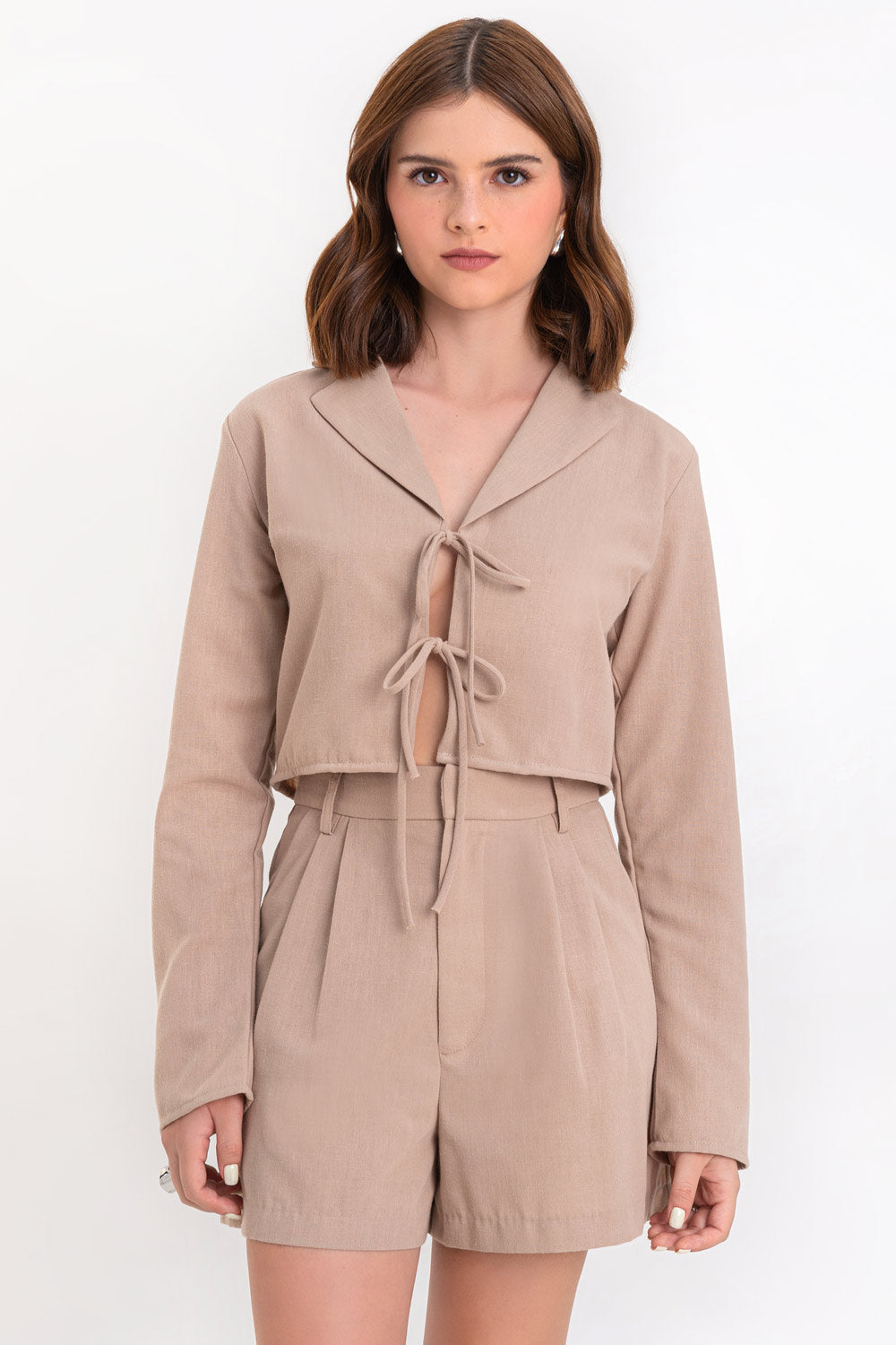 Blusa corta de fit fluido, manga larga, escote v con solapa y cierre frontal con lazos amarrables.