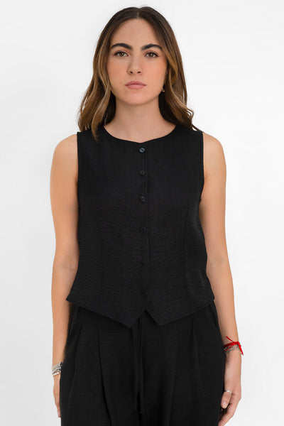 Blusa corta fluida de fit recto, cuello redondo, sin mangas y cierre frontal con hilera de botones. Detalle de abertura frontal en bajo.