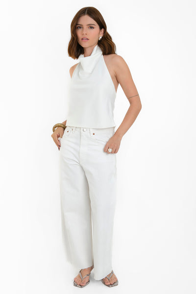 Blusa corta halter de fit fluido, sin mangas, cuello halter fluido con plisados y escote en espalda. Cierre posterior con botón y ojal.