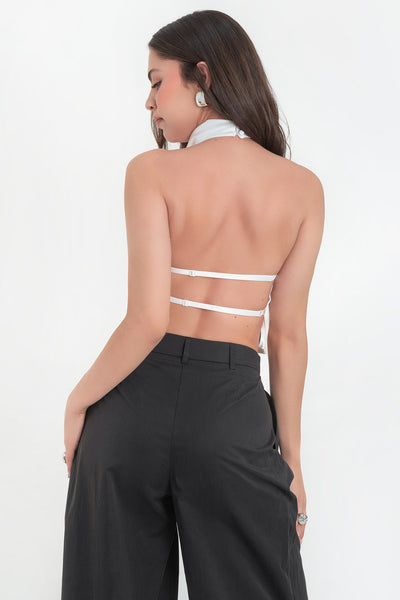 Blusa corta satinada de cuello halter con escote fluido, sin mangas y escote en espalda con tirantes delgados ajustables.