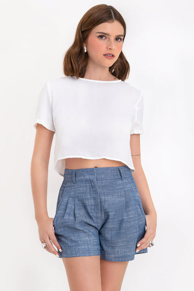 Blusa corta de fit ligeramente oversized, de cuello redondo, manga corta y cierre posterior con botón y ojal.