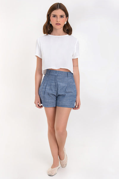 Blusa corta de fit ligeramente oversized, de cuello redondo, manga corta y cierre posterior con botón y ojal.