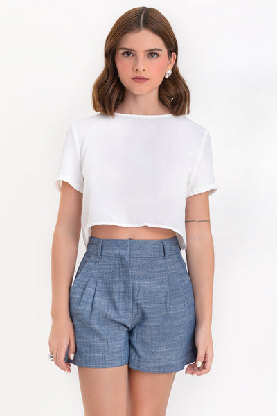 Blusa corta de fit ligeramente oversized, de cuello redondo, manga corta y cierre posterior con botón y ojal.